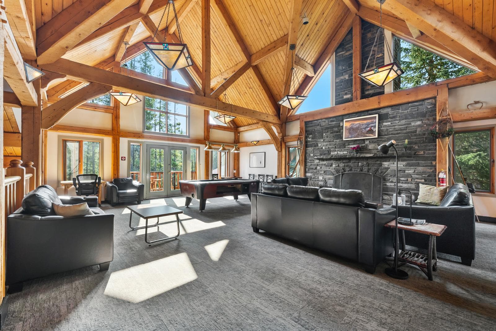 Lodge common room with sofas, fireplace, and pool table