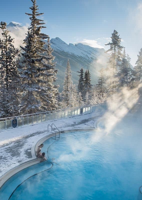 Outdoor hot spring pool in the snow with mountain views